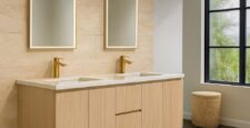 Modern bathroom with two mirrors, double sink vanity in a light wood finish, gold faucets, and a window. Text overlay says, Affordable Custom Bathroom Vanities ready in 2 weeks.