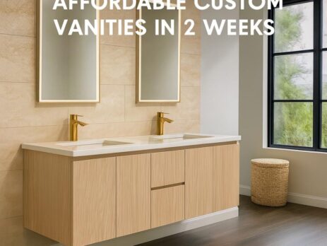 Modern bathroom with two mirrors, double sink vanity in a light wood finish, gold faucets, and a window. Text overlay says, Affordable Custom Bathroom Vanities ready in 2 weeks.