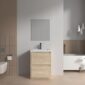 Modern minimalist bathroom featuring the Arvia 24 inch Bathroom Vanity with Sink, a rectangular mirror, wall-mounted toilet, toilet paper holder, and a white bathtub with gold fixtures in neutral beige and white tones.