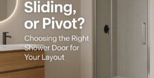 Modern bathroom with a wooden vanity, round mirror, and glass shower enclosure. Text reads: Swing, Sliding, or Pivot? Choosing the Right Shower Door for Your Layout.