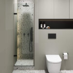 A modern bathroom featuring the Nova Hinged Frameless Shower Door, terrazzo walls and floor, a wall-mounted white toilet, toilet paper holder, black flush plate, and a shelf with bottles and decor.