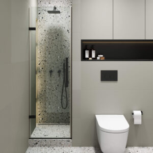 A modern bathroom featuring the Nova Hinged Frameless Shower Door, terrazzo walls and floor, a wall-mounted white toilet, toilet paper holder, black flush plate, and a shelf with bottles and decor.