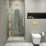 Modern bathroom with the Nova Hinged Frameless Shower Door and gold fixtures, terrazzo walls and floor, a wall-mounted toilet with a gold flush button, plus storage shelves for toiletries.