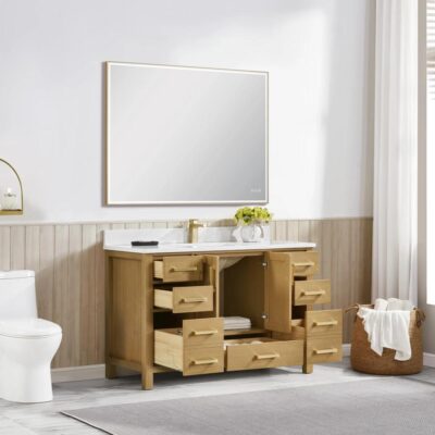 A bright bathroom features a large mirror above a light wood vanity from the Basel Bathroom Vanity Collection. All drawers and doors are open, revealing empty storage spaces. A toilet sits on the left, sunlight streaming through sheer curtains.