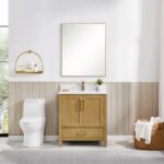 A modern bathroom with a Basel 30 Inch Bathroom Vanity and sink, a large mirror above, white toilet, wall shelf holding toiletries, and a basket of towels on the floor. Light wood paneling and a window complete the bright, clean space.