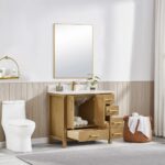 A modern bathroom showcases the Basel 36 Inch Bathroom Vanity with open drawers displaying towels, a toilet on the left, a wicker basket of towels on the right, and a large mirror with a plant above, all brightened by natural light.