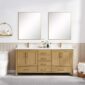 A modern bathroom features a Basel 72 Inch Double Bathroom Vanity with gold fixtures, two large mirrors, a plant, soap dispensers, a white toilet, and a shelf with toiletries. The walls are half-paneled with light wood.