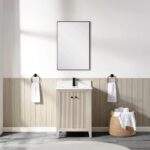 A minimalist bathroom features the Torino 24 Inch Bathroom Vanity Cabinet with a rectangular mirror above, towel rings holding white hand towels on either side, and a wicker basket of rolled towels on the floor to the right.