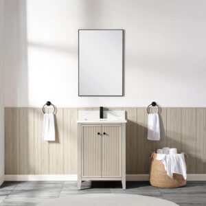 A minimalist bathroom features the Torino 24 Inch Bathroom Vanity Cabinet with a rectangular mirror above, towel rings holding white hand towels on either side, and a wicker basket of rolled towels on the floor to the right.