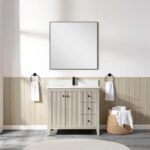 A modern bathroom features a square mirror above a Torino 36 Inch Bathroom Vanity Cabinet with Drawers, black faucet, two towel rings with white towels, and a wicker basket holding rolled towels on a tiled floor.