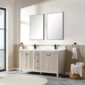 A modern bathroom features the Torino 60 Inch Double Bathroom Vanity Cabinet, two rectangular mirrors, black faucets, towel rings with white towels, a window, and a basket of rolled towels on a marble floor.