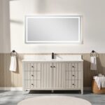 A modern bathroom showcases the Torino 60 Inch Single Bathroom Vanity with multiple drawers and a central cabinet, topped by a large illuminated mirror. Neutral, minimal decor includes towels on both sides and rolled towels on stools.