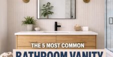 A modern bathroom with a wooden vanity, round mirror, wall sconces, and a woven hamper. Text overlay reads: The 5 Most Common Bathroom Vanity Mistakes We See In Showrooms. Avoid these common bathroom vanity mistakes when designing your space.