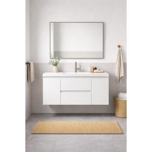 Modern bathroom with a Paterno 42 Inch Wall Mount Bathroom Vanity, wide mirror, beige towels, a woven basket, and natural fiber rug on gray tile floors. The space is minimalistic with neutral colors and clean lines.